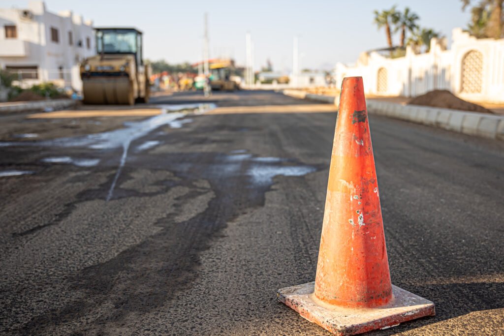 Close up of an orange traffic cone on the road copy space.